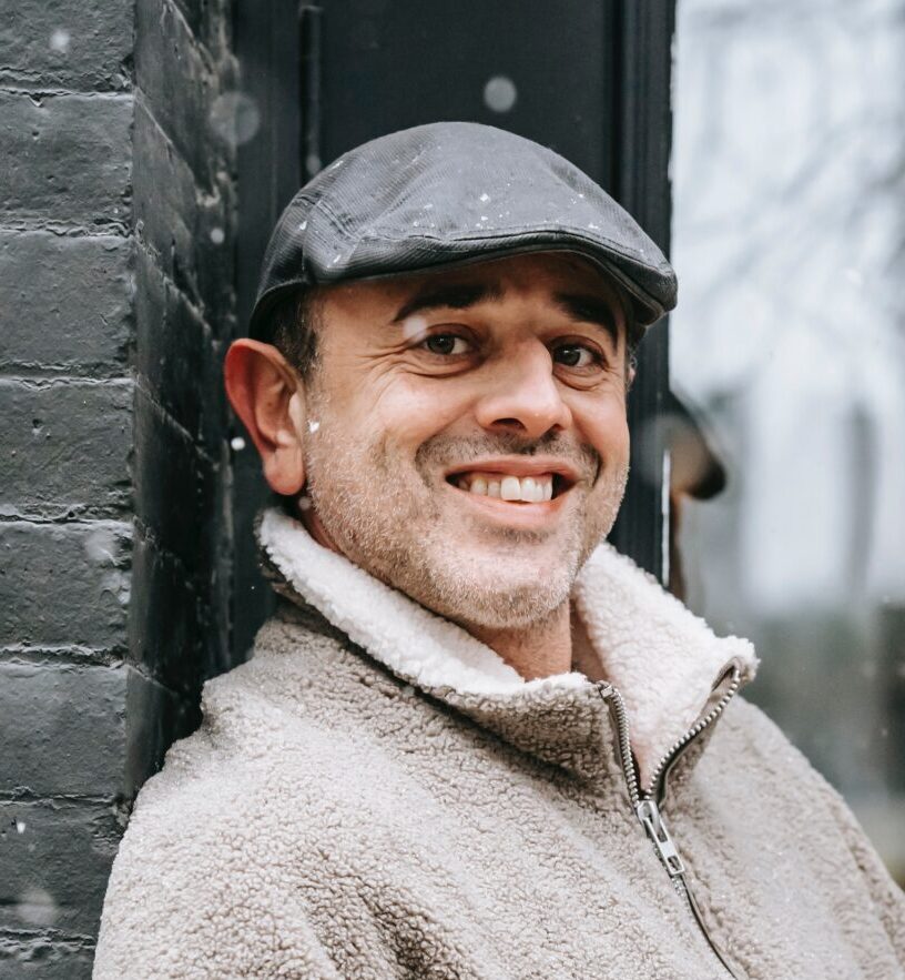 A Man Smiles Holding a Coffee in the Snow