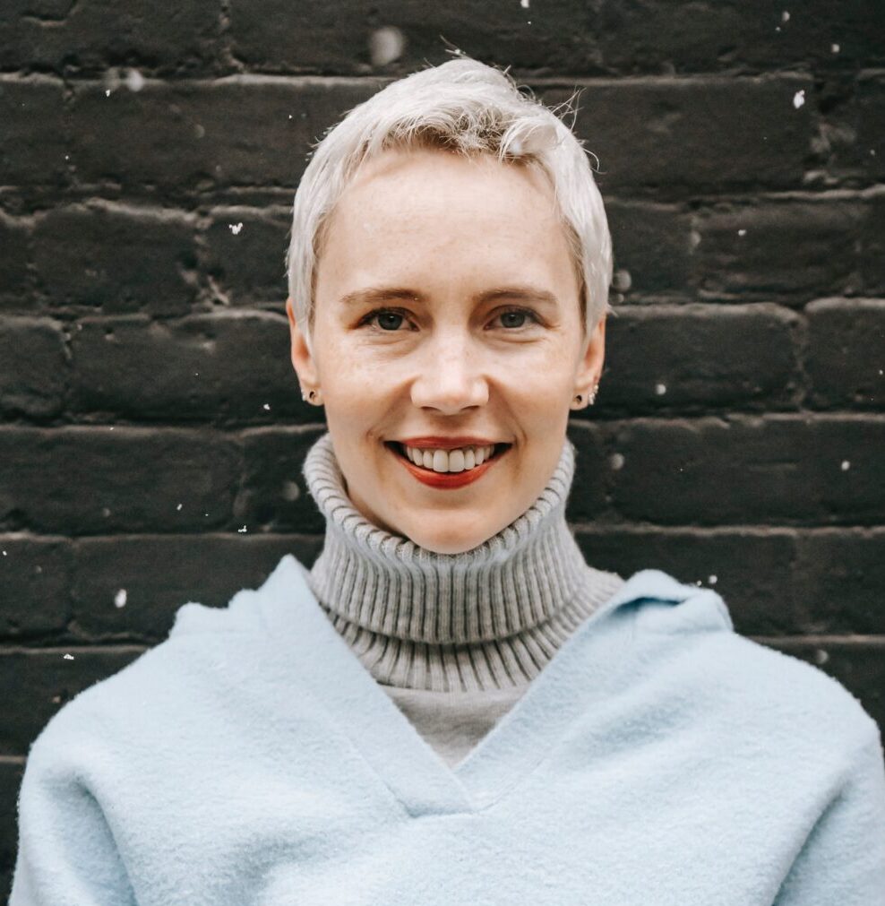 A Woman in a Blue Jumper Smiles in the Snow