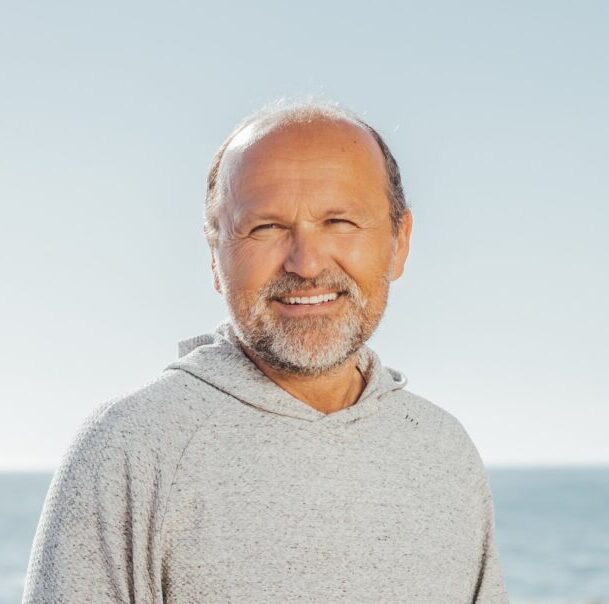 A smiling man standing on the beach